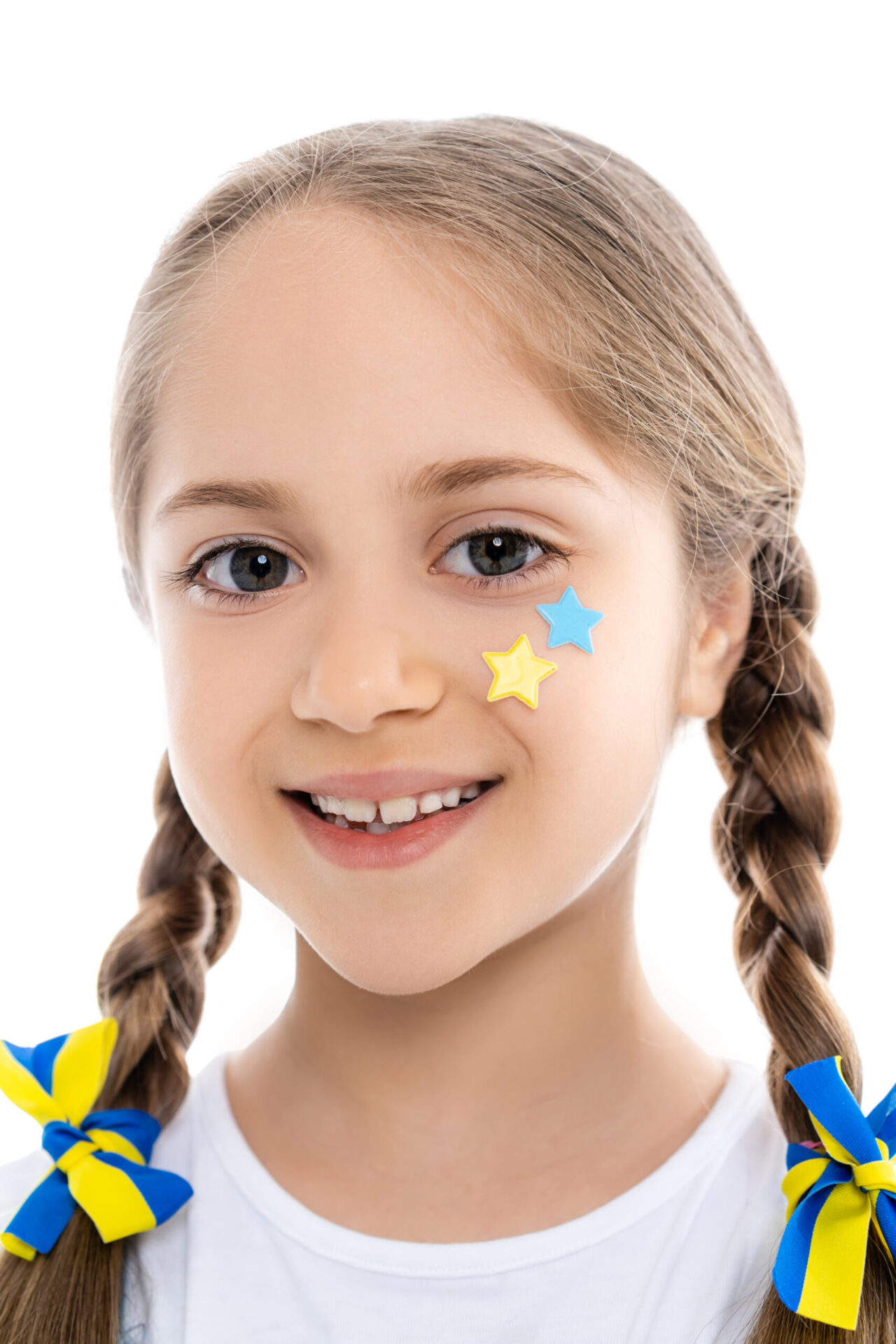 Patriotic Girl With Blue And Yellow Stars And Ribbons Smiling At Camera Isolated On White